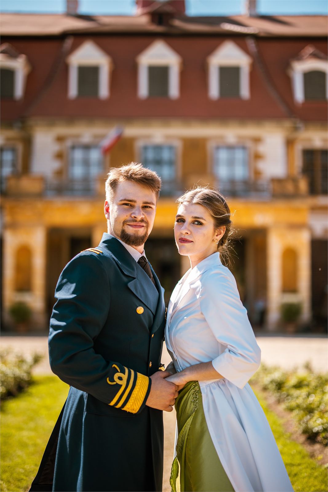 Dvojice v kostýmech před zámeckou fasádou v Rájci nad Svitavou